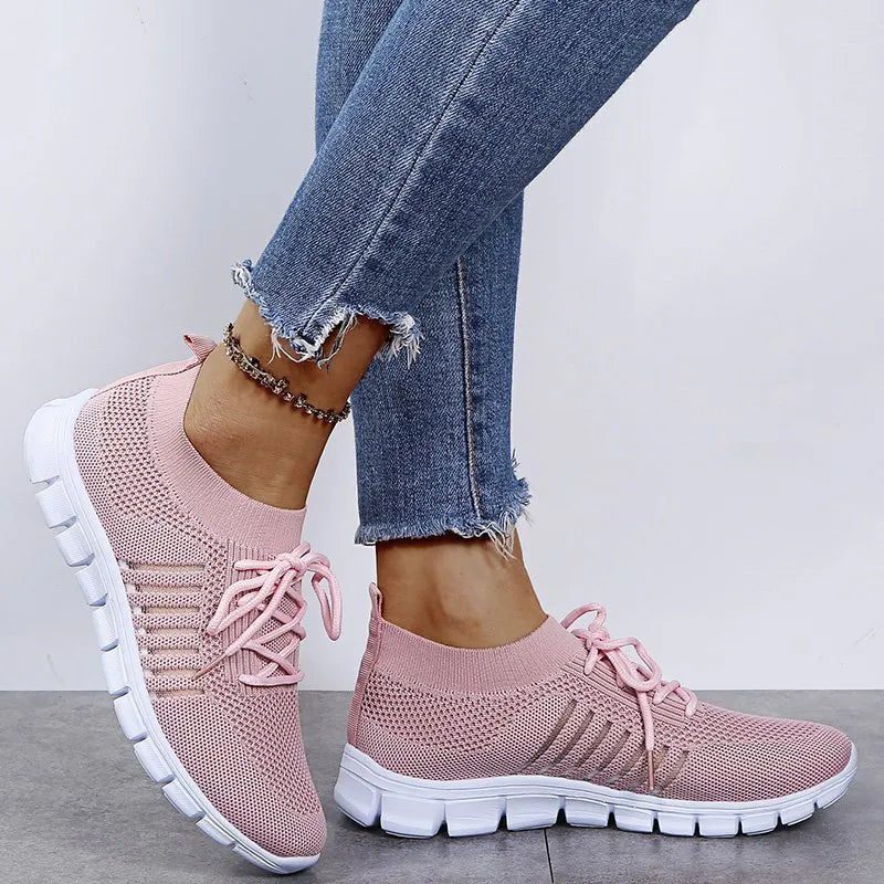 Pink knit runner sneakers with ribbed lace-up detail and white soles.