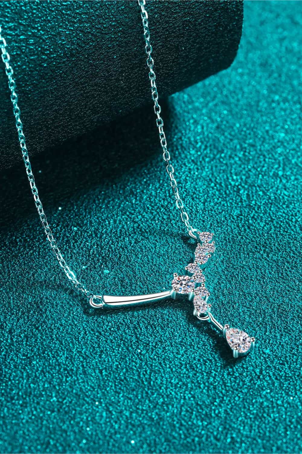 Silver asymmetrical moissanite cluster pendant necklace with a pear-shaped drop.
