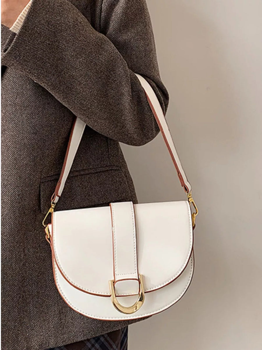 Chic white semi-circular flap crossbody bag with gold hardware and brown trim.