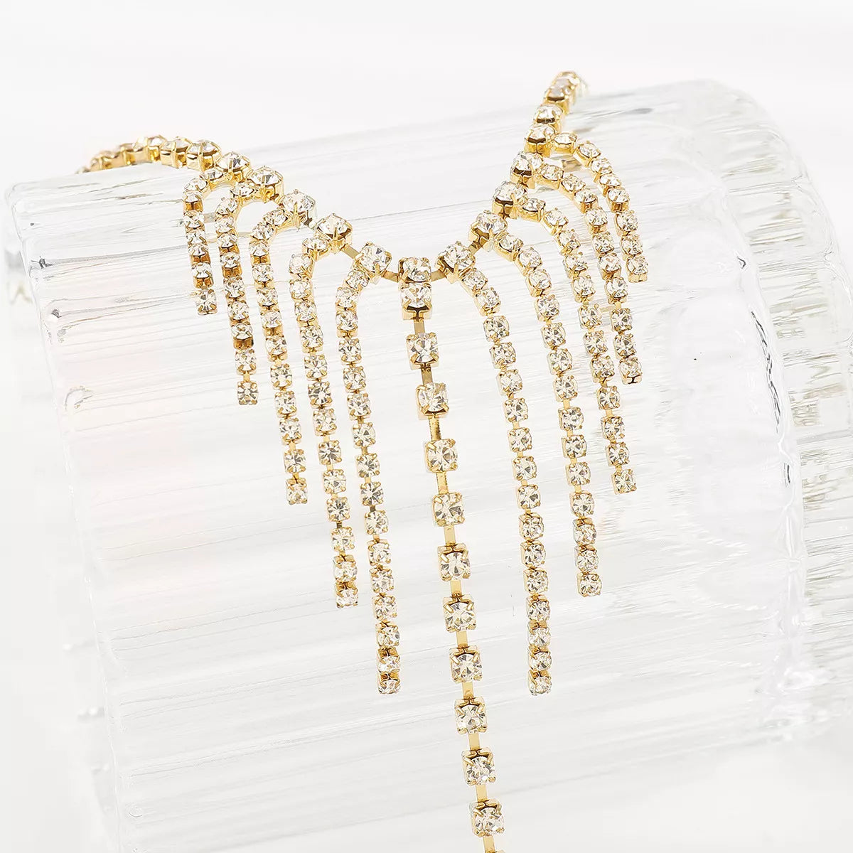 Gold rhinestone fringe hand chain bracelet with 18K gold plating.