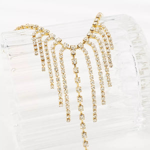 Gold rhinestone fringe hand chain bracelet with 18K gold plating.