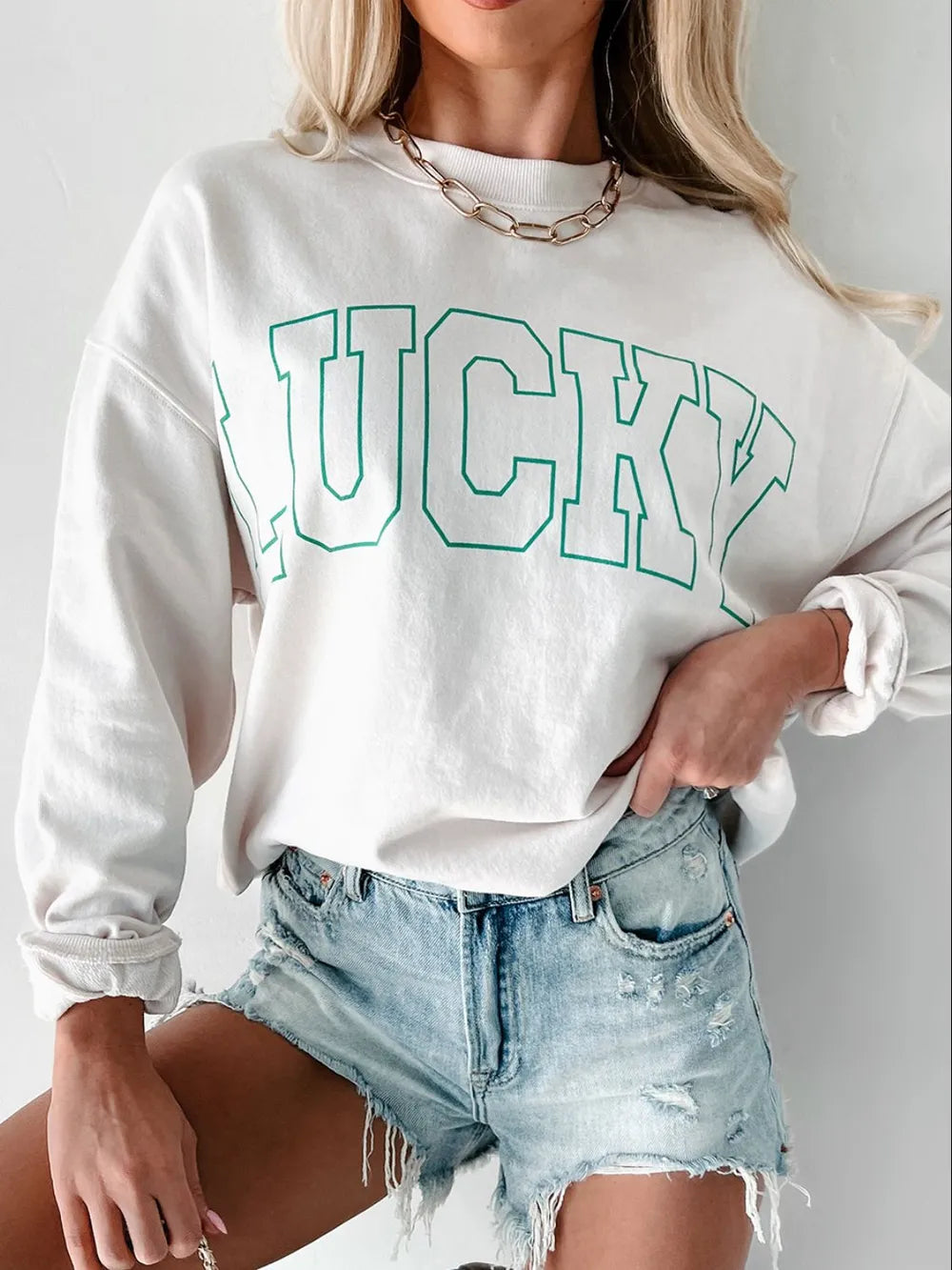 White sweatshirt with green varsity "LUCKY" graphic and crew neck