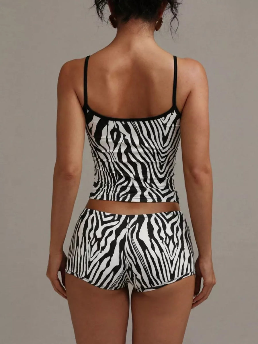 Women's zebra print cami and shorts pajama set with black trim.