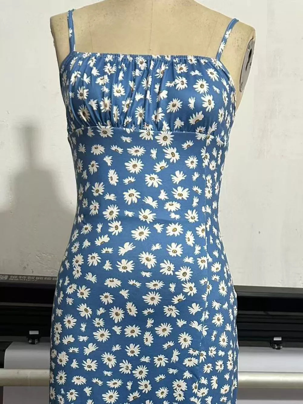 Sky blue spaghetti strap midi dress with white daisy print and ruched bust.