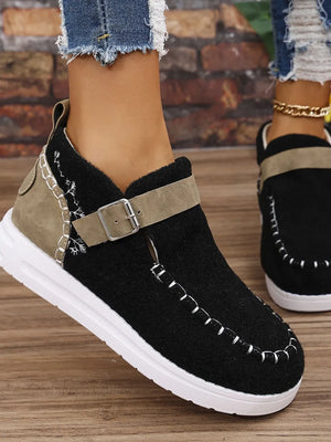 Black textured sneakers with stitch detail and buckle strap.