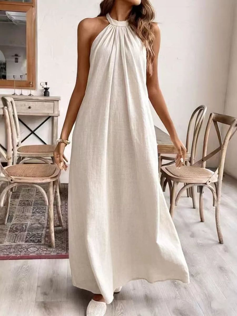Cream white ruched halter maxi gown with gathered neckline and flowing skirt.