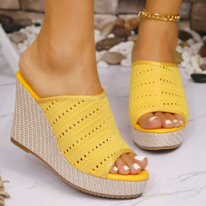 Yellow perforated espadrille wedge sandals with a woven wedge heel.
