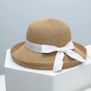 Elegant straw sun hat with white ribbon detail and bow