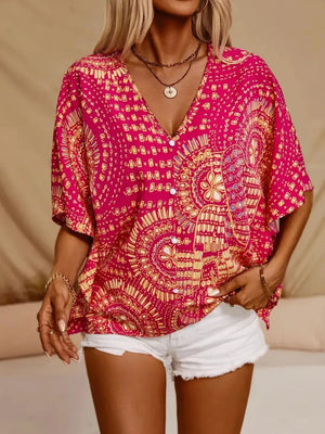 Bohemian print v-neck t-shirt in hot pink with short sleeves and button front, styled with white shorts.