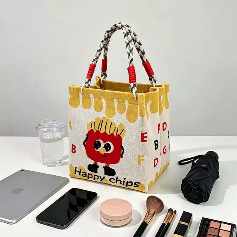 Cartoon graphic tote handbag with french fry character and alphabet print, yellow trim, and braided handles.