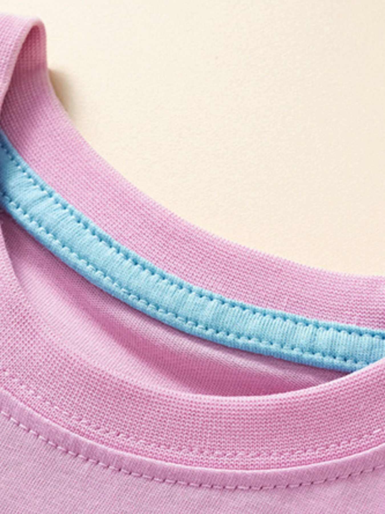 Pink toddler t-shirt with blue contrast stitching detail on the neckline.
