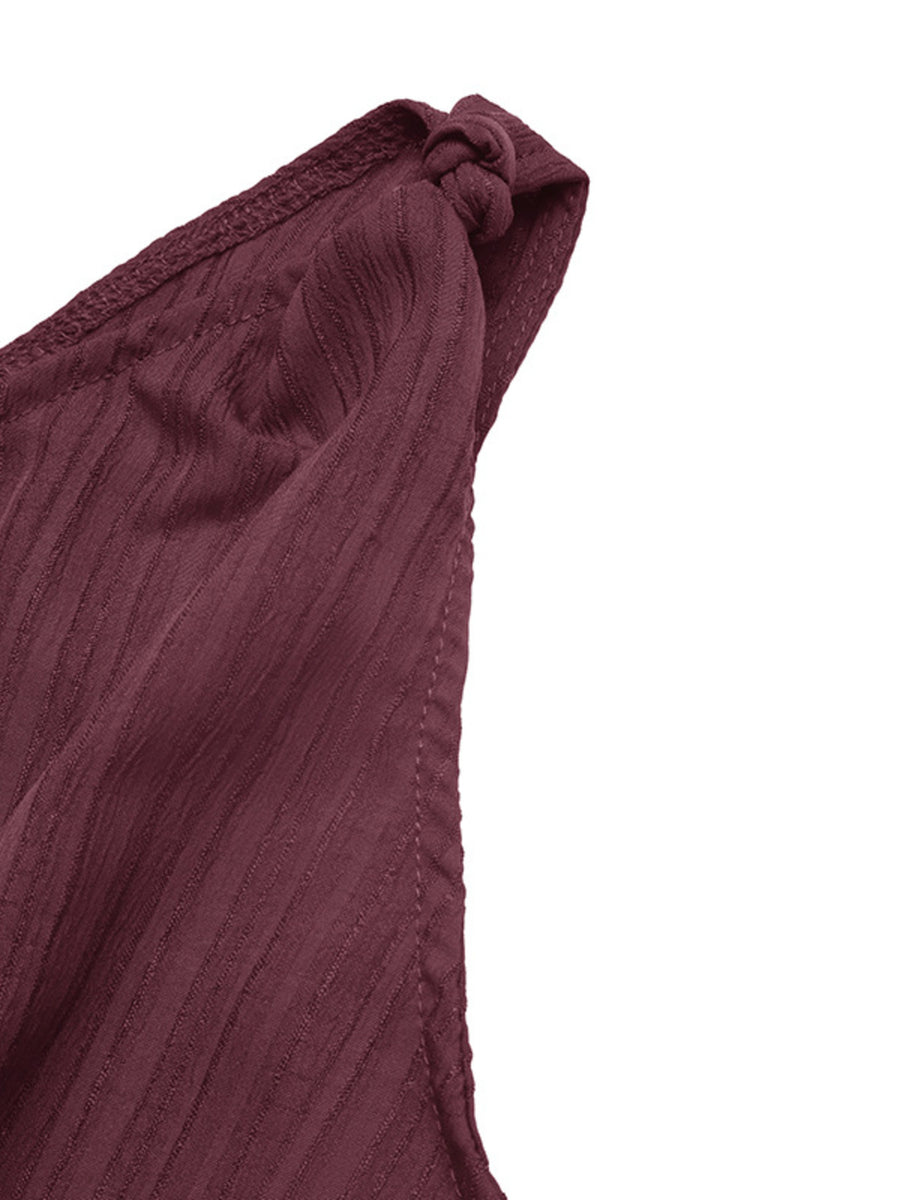Burgundy one-shoulder romper with textured fabric and knot detail.