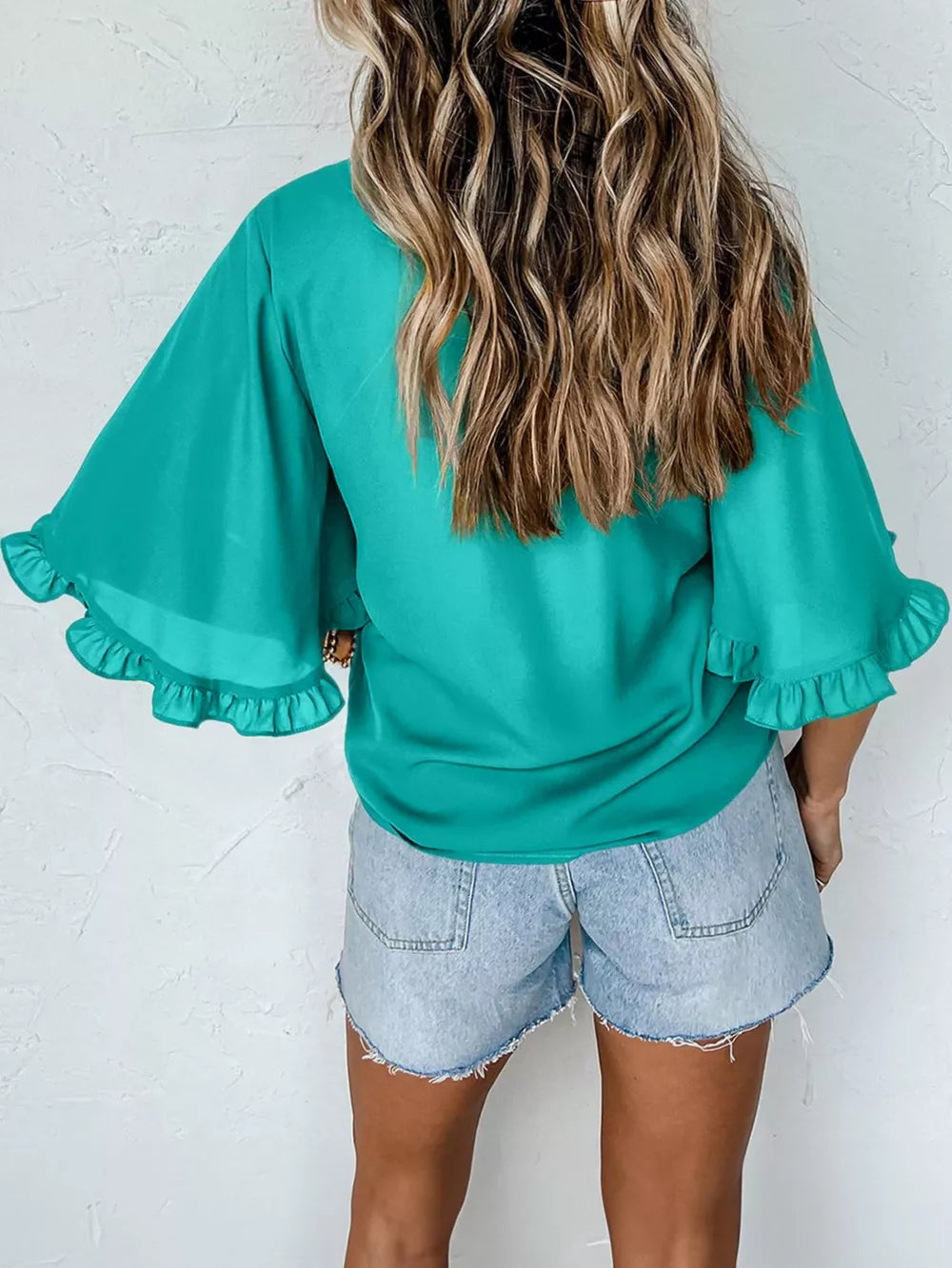 Teal ruffled mock neck half sleeve shirt with flared sleeves.