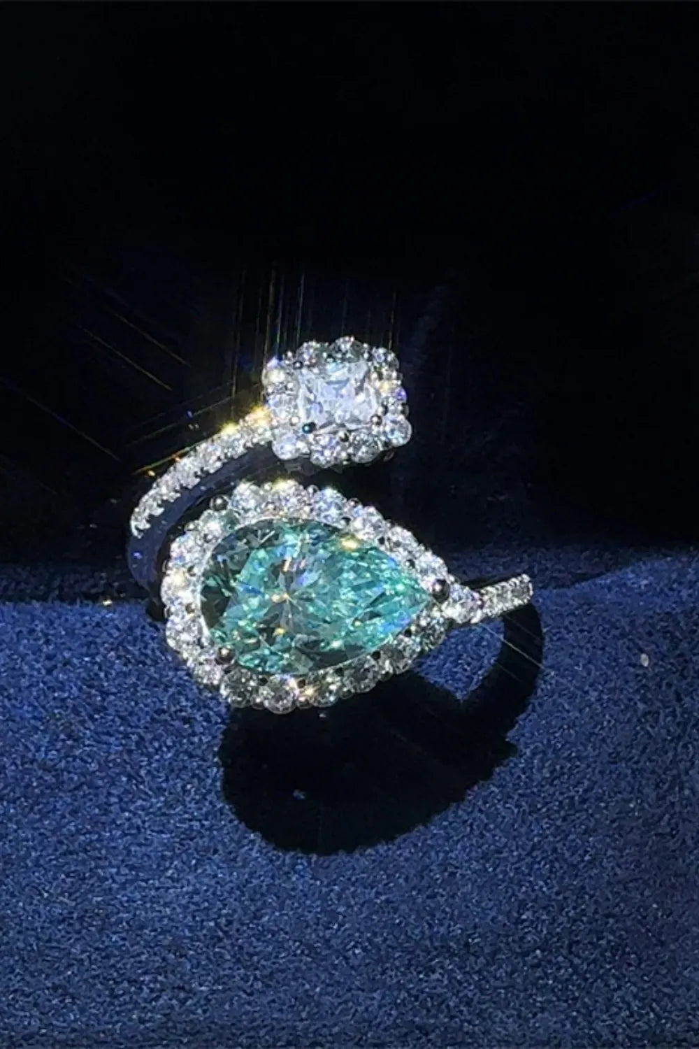 Bypass ring with turquoise pear-cut moissanite and diamond halo, adjustable band.