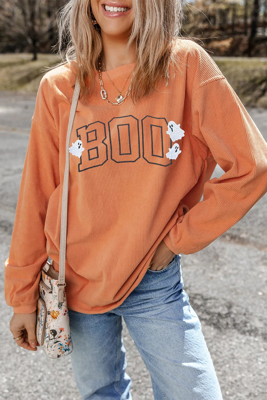 Corduroy sweatshirt in sherbet orange with "Boo" appliqué and ghost details.