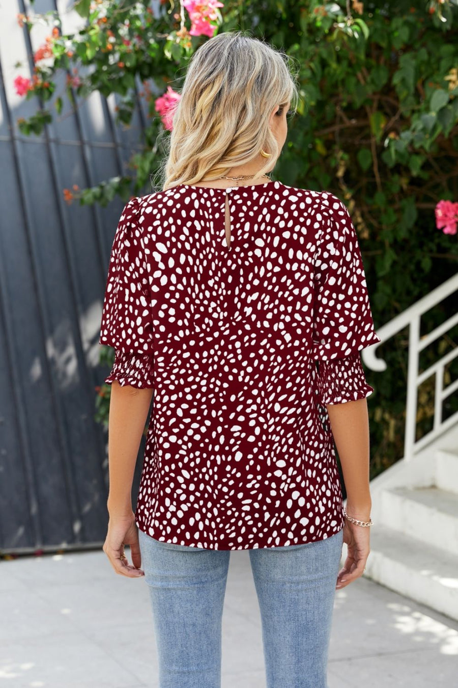 Burgundy blouse with white spot print, shirred short sleeves, and keyhole back detail.