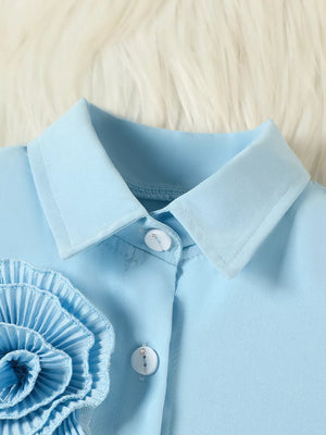 Blue toddler shirt with floral appliqué and decorative buttons