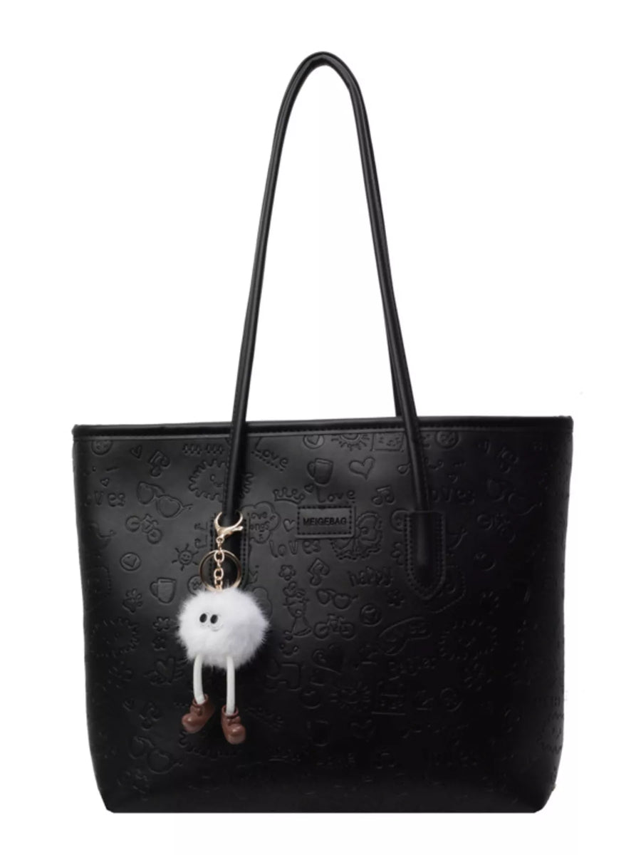 Black embossed PU leather tote bag with a cute fuzzy charm and playful all-over print.