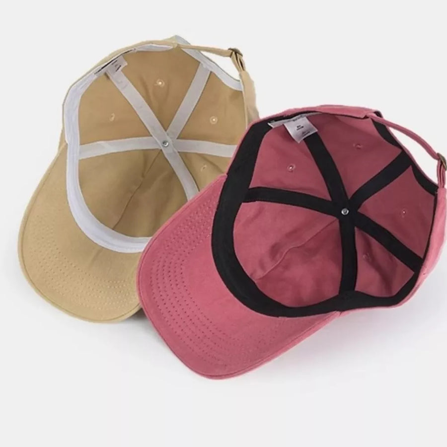 Vintage washed cotton baseball caps in khaki and raspberry powder, showing interior detail.