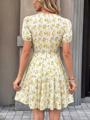 White floral print mini dress with short puff sleeves and a pleated skirt.