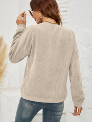 Beige corduroy sweatshirt with crewneck and long sleeves, styled with jeans.
