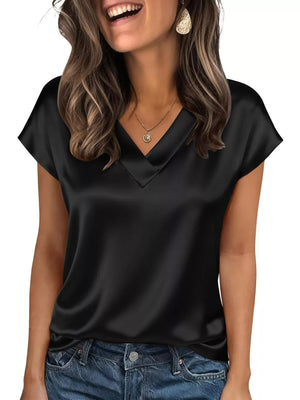 Black satin V-neck blouse with short sleeves, styled with jeans and a necklace.