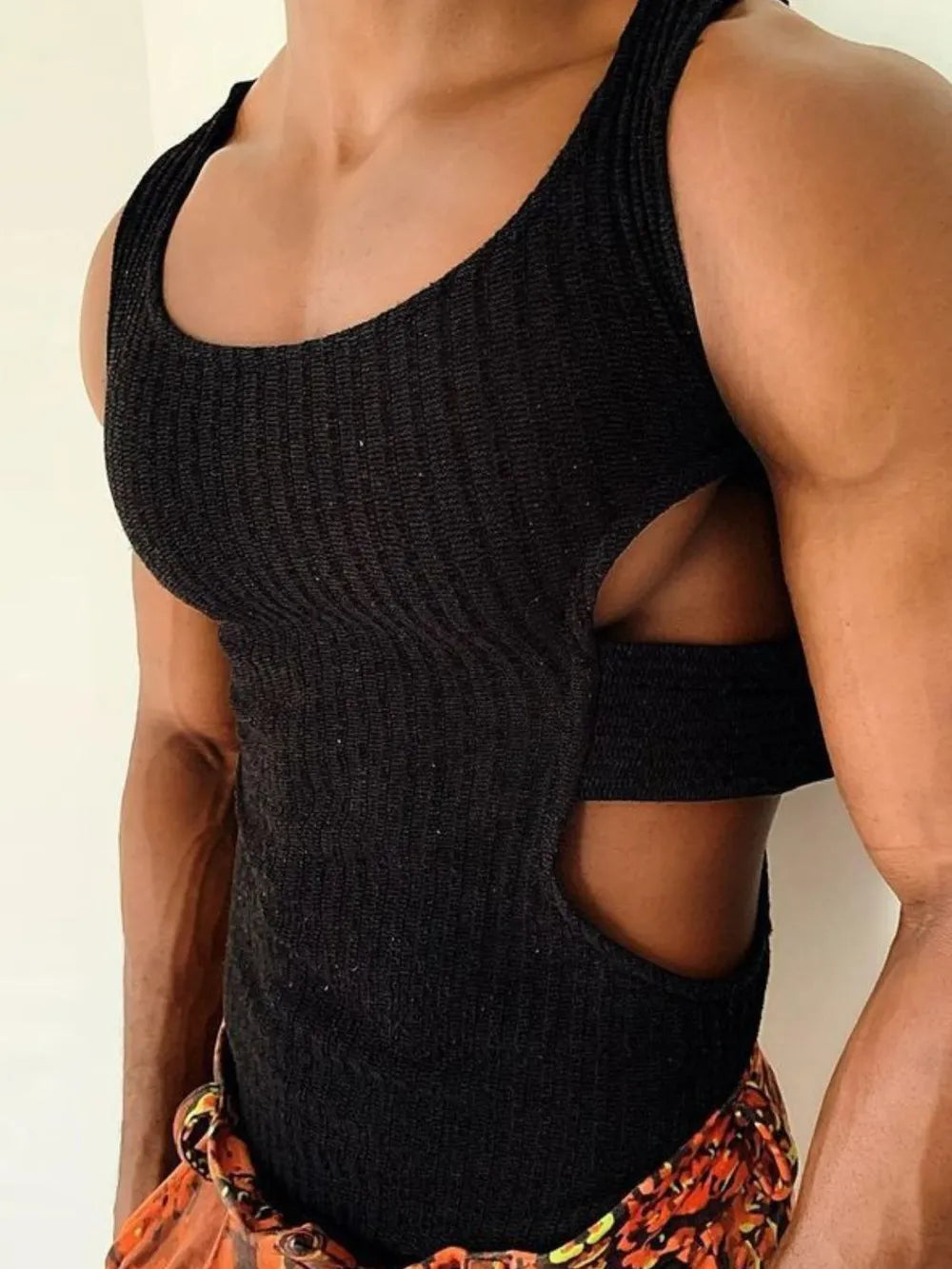 Black ribbed knit tank top with side cutouts and a strap detail.