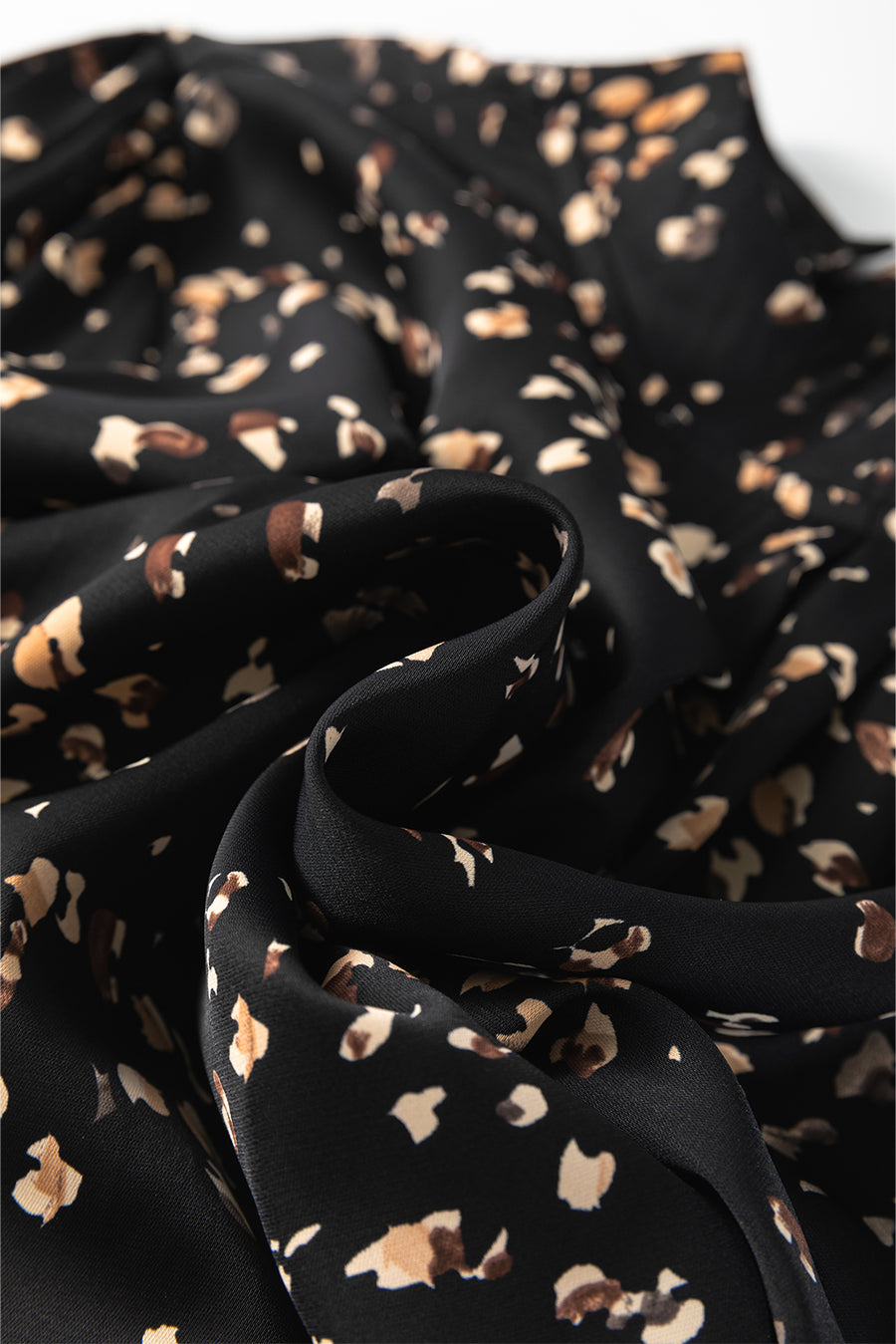 Black abstract print blouse with a high neckline.