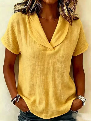 Yellow textured blouse with short sleeves and a V-neck collar.