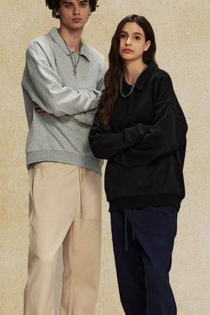 Oversized polo sweatshirt with collar in black and gray, featuring a relaxed fit and casual styling.