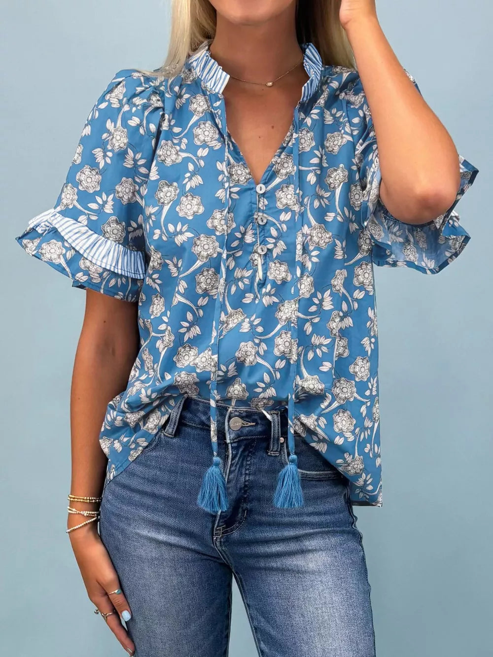 Blue floral cotton blouse with ruffle sleeves and tassel tie neckline