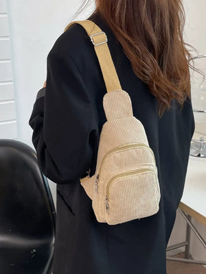 Khaki corduroy sling bag with zip pockets worn crossbody
