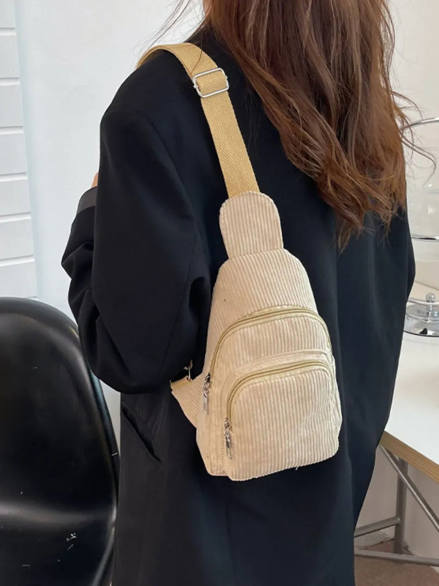 Khaki corduroy sling bag with zip pockets worn crossbody