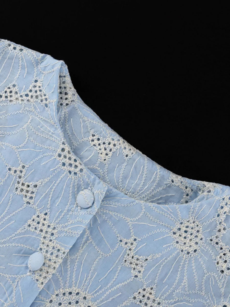 Light blue cotton eyelet top with white floral embroidery and button detail