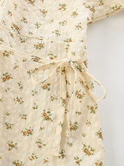Cream floral puff sleeve toddler dress with a tie waist and button detail.
