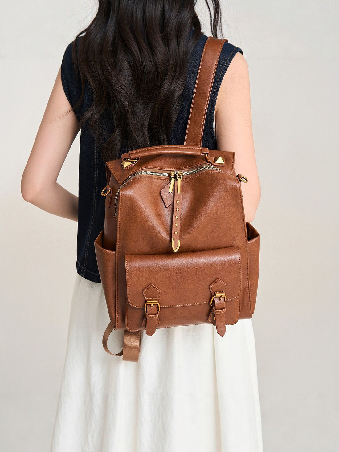 backpack in cognac brown featuring top handle and boxy fit
