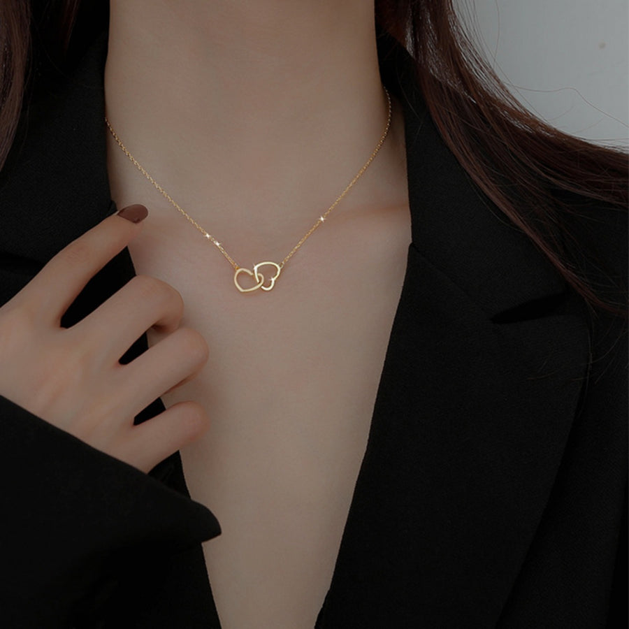 Gold interlocking heart pendant necklace on a delicate chain.