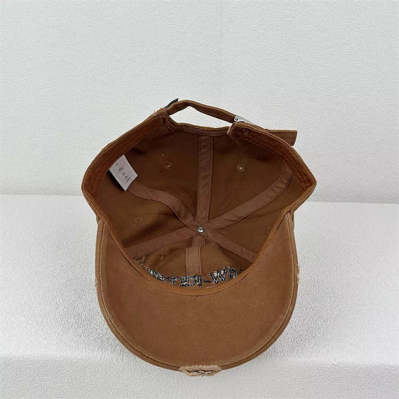 Brown baseball cap with embroidered text and distressed brim detail.