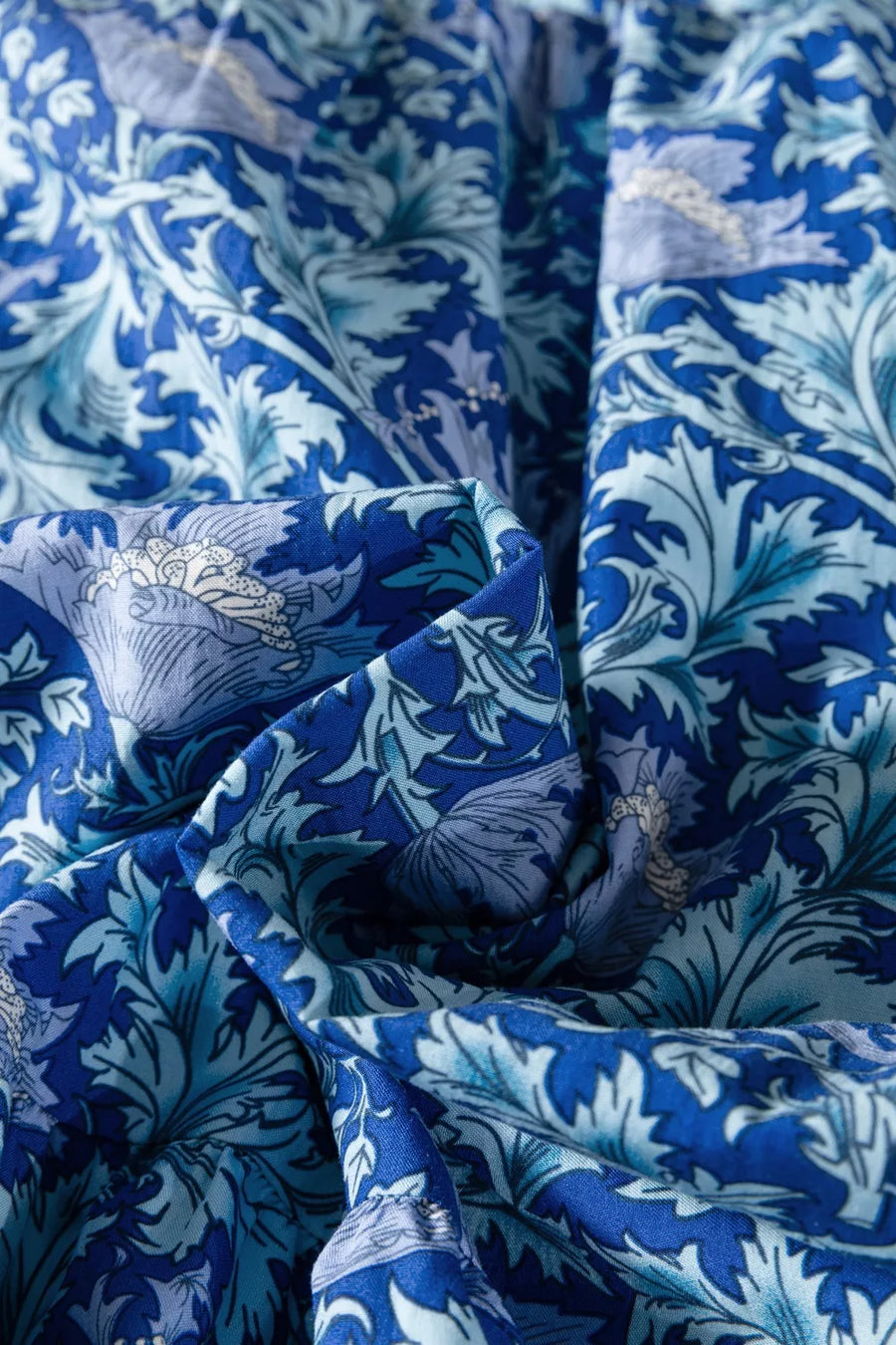 Floral tiered midi dress in blue cotton with frilled cuffs and cinched waist detail.