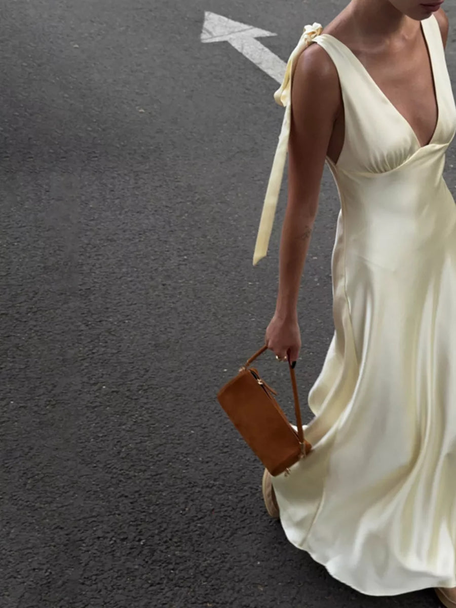 Cream satin slip dress with tie shoulder straps and a deep V-neck.
