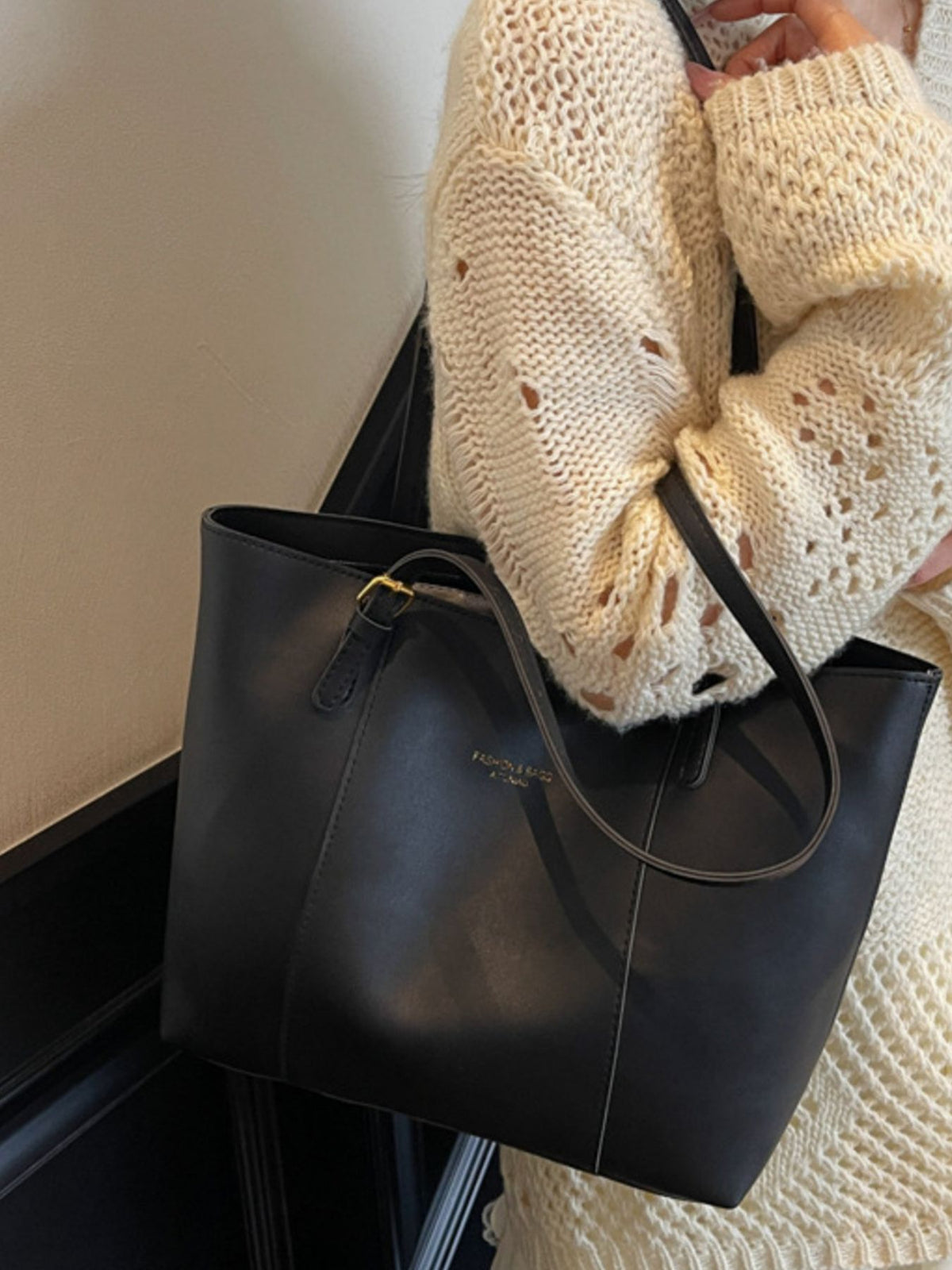 Black structured pu leather tote bag with gold buckle detail and subtle logo
