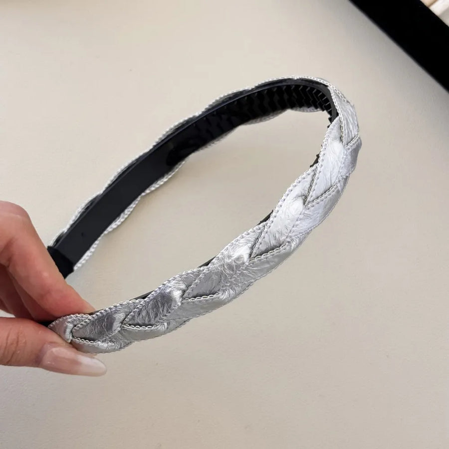Silver woven faux leather braided headband with black interior.