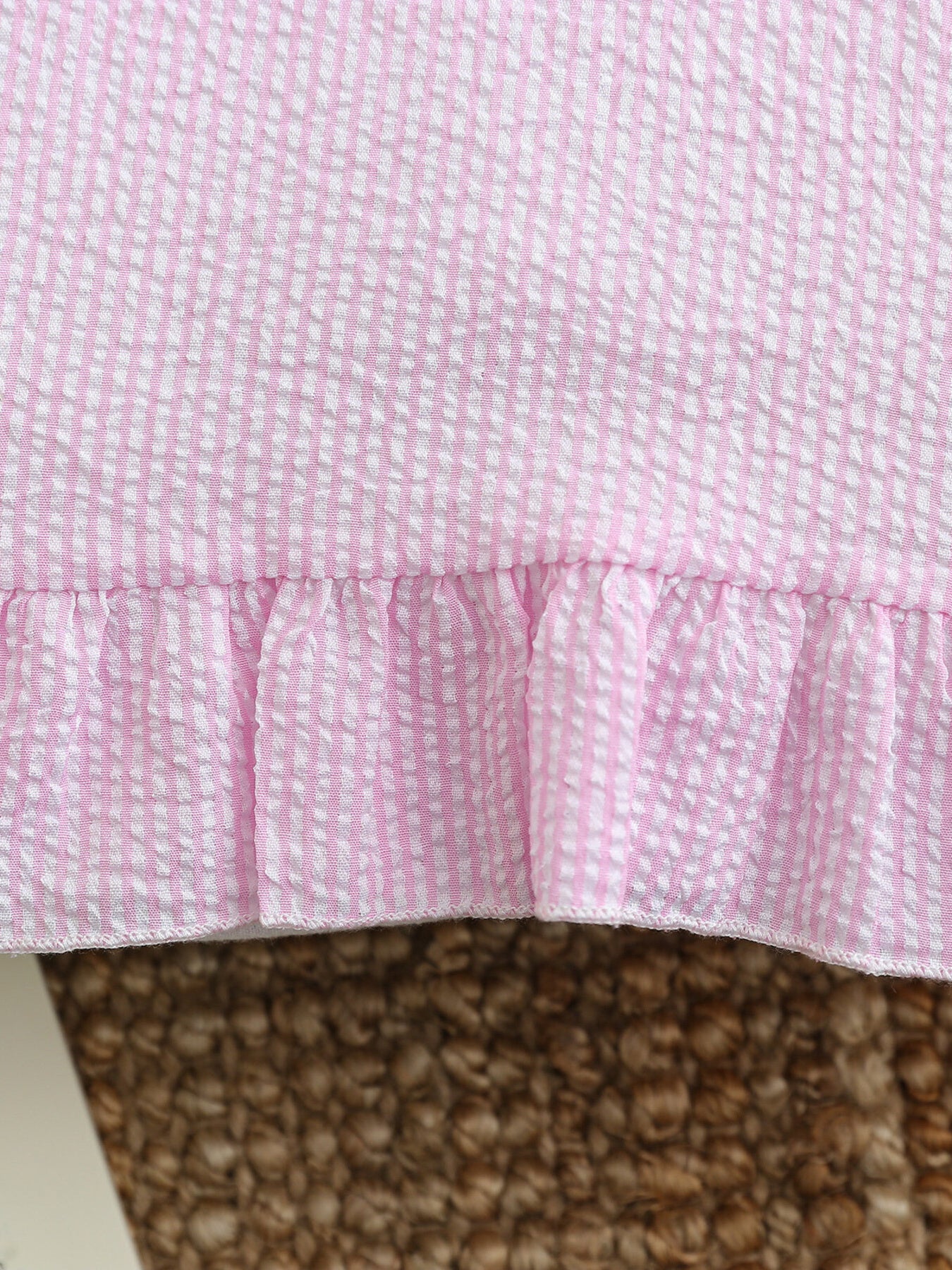 Pink and white seersucker baby dress with ruffled hem detail