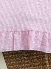 Pink and white seersucker baby dress with ruffled hem detail