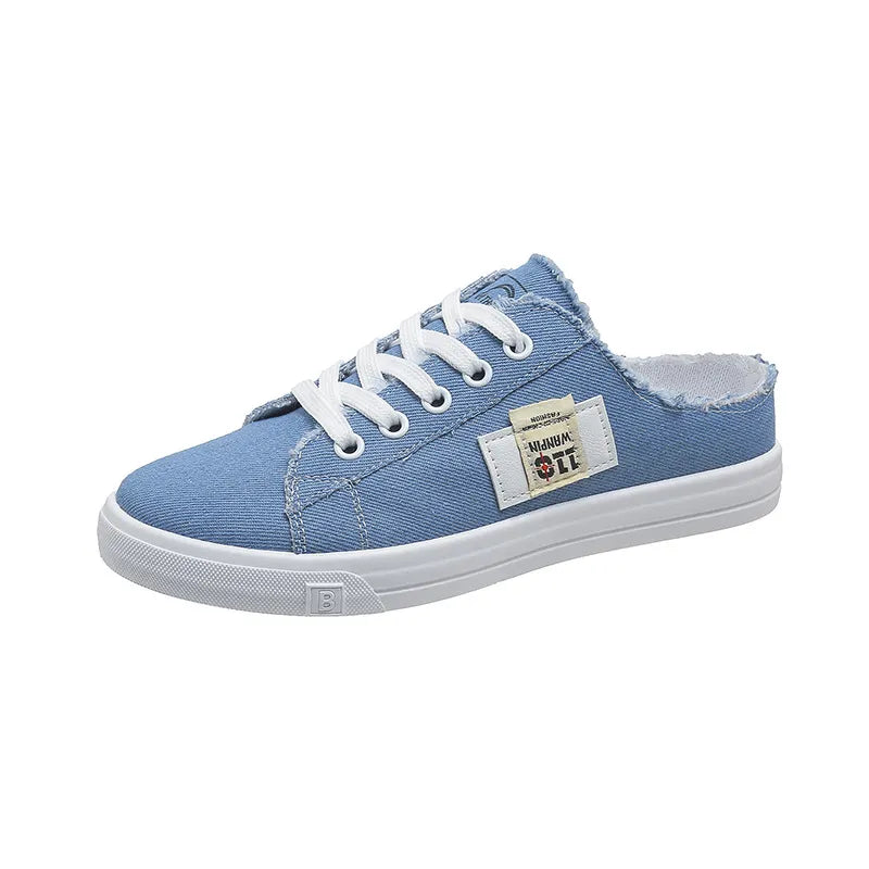 Light blue denim mule sneakers with raw edges and white laces.
