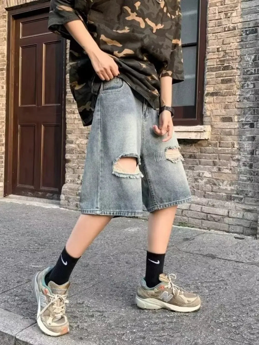 Relaxed fit distressed denim shorts in blue with ripped details and a baggy cut.