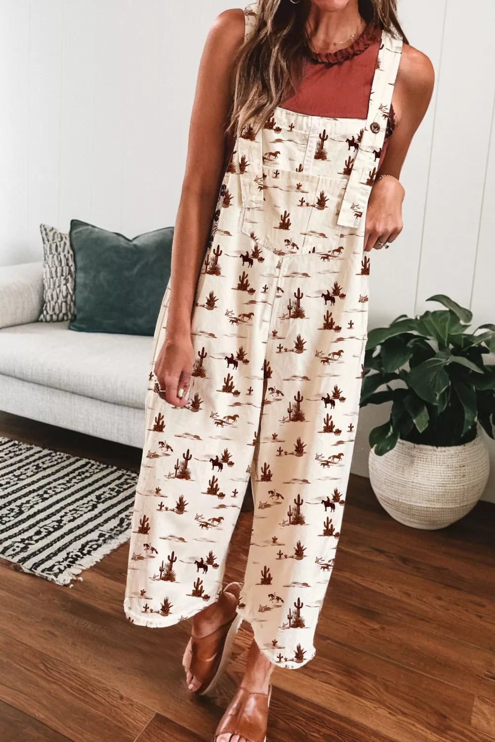 Desert motif adjustable jumpsuit in beige cotton with cropped legs and a desert landscape print.