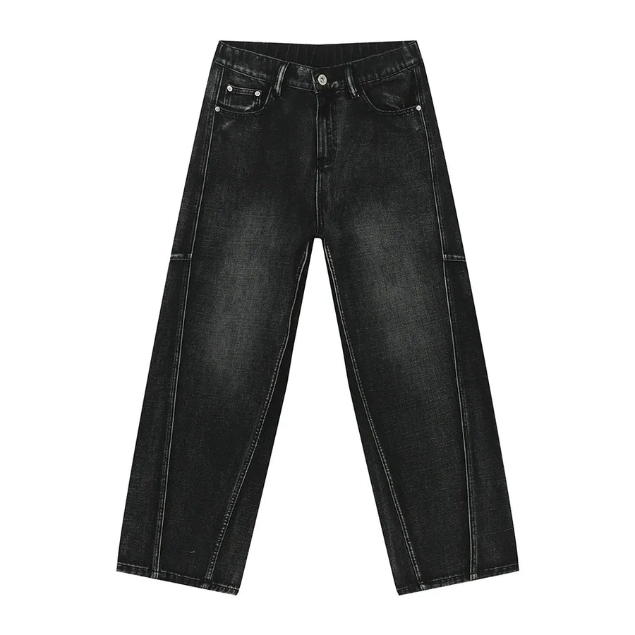 Dark wash denim trousers with exaggerated seam details and a wide leg.