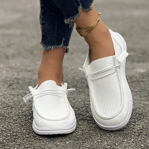 White corduroy boat shoes with lace detail and a low profile sole.
