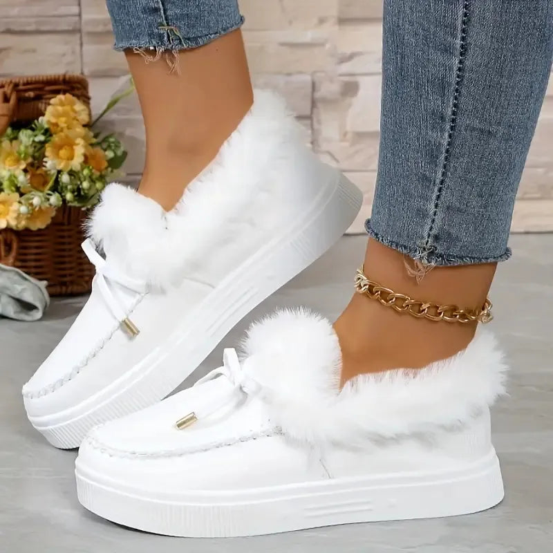 White suede loafers with shearling trim and tie detail.